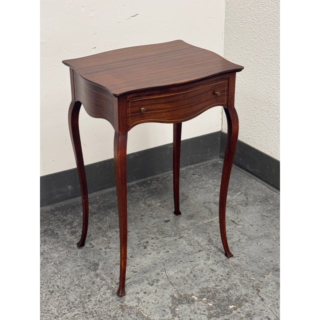 Design Plus Gallery presents a Vintage Edwardian Side Table. The mahogany table has a shaped rectangular top, serpentine...