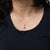 A 0.83-carat padparadscha sapphire in an oval cut anchors this solid 14K white gold pendant, lined with twenty-five earth-...