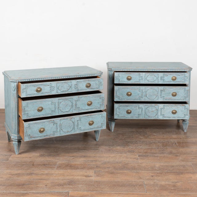 A pair of elegant Gustavian oak chests of three drawers painted in soft shades of blue. Canted fluted side posts with...