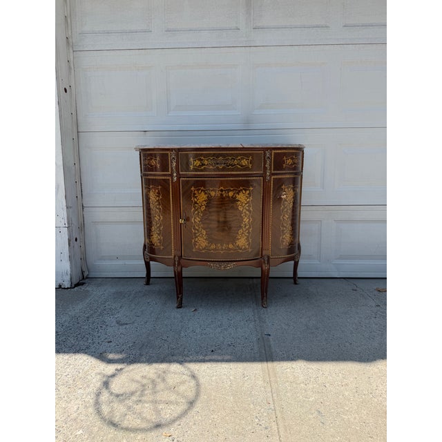 We have an absolutely gorgeous vintage French Louis XV Revival marquetry cabinet for sale. It features a beautifully...