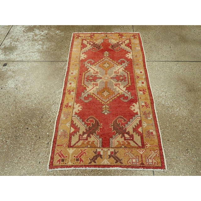 A vintage Turkish Oushak throw rug. A serrated edge hexagonal mauve medallion sprouts four large, aggressive diagonal...