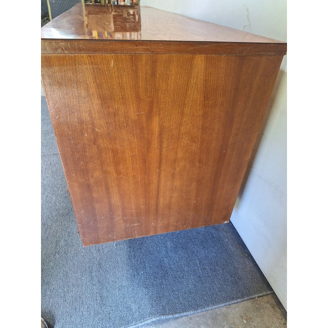 This Dixie dresser is made of wood, walnut, and veneers. It's an excellent example of the Mid Century furniture style. It...