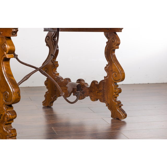 An Italian Baroque style walnut Fratino console table from the 19th century with carved lyre shaped legs and iron...