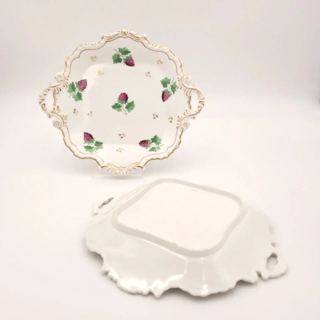 A pair of English porcelain gilt dessert serving pedestals, painted with raspberries. Circa 1830.