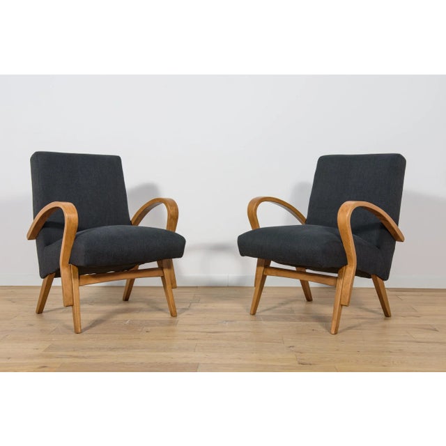 This set of two Czechoslovak armchairs was produced in the 1960s. The wooden elements have been cleaned, painted with oak-...