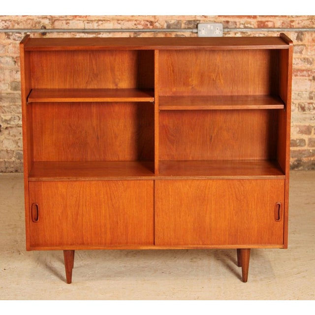 Mid Century teak bookcase, circa 1960s. 2 adjustable shelves and 2 cabinets with sliding doors. Excellent restored...