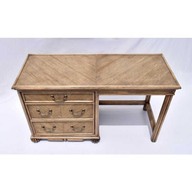 Pencil reed rattan writing desk of solid wood construction in a geometric Chevron pattern with original brass hardware,...