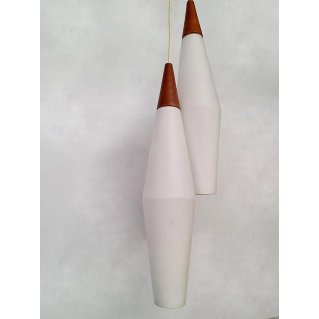 Two or a kind! this beautiful timeless set of two beautiful milk glasses drop hanging lamps with teak wooden "top". Nice...