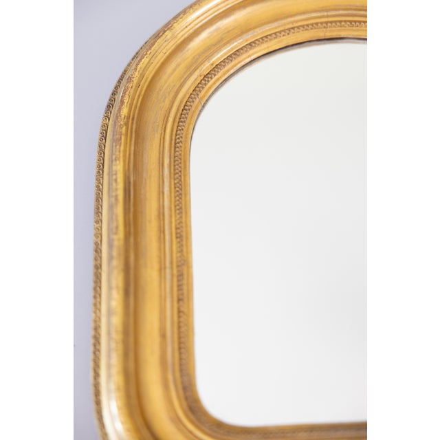 A gorgeous petite antique 19th-Century French Louis Philippe gilt wood and gesso mirror. This beautiful mirror has...