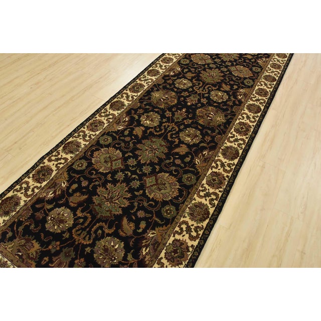 A traditional Agra runner hand-knotted with an all-wool pile on a cotton foundation. This finely woven oriental rug...