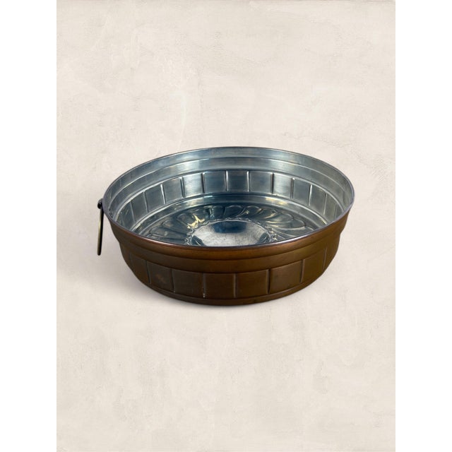 An antique English tin-plated mould dating to circa 1900, featuring a beautifully fluted design with a domed center....