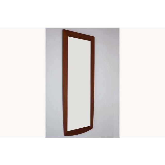 A beautifully elegant wall mirror with a subtly tapering frame in teak and curved ends. Original fixing on the back for...