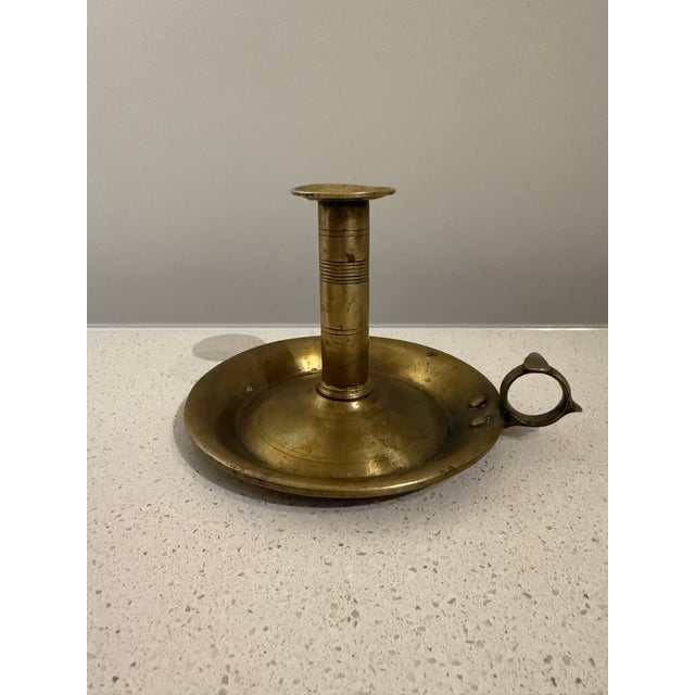 Antique brass chamberstick candle holder featuring a traditional push-up mechanism, circular drop pan and finger-loop...