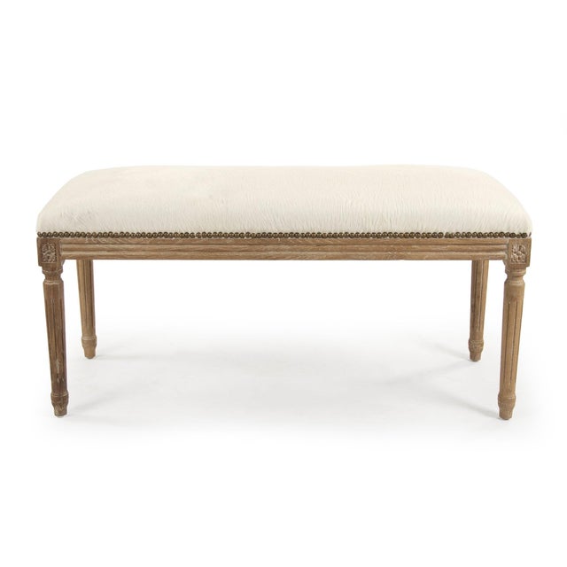 This is a bench featuring a sophisticated design with cowhide upholstery and an oak wood frame. The upholstery showcases a...