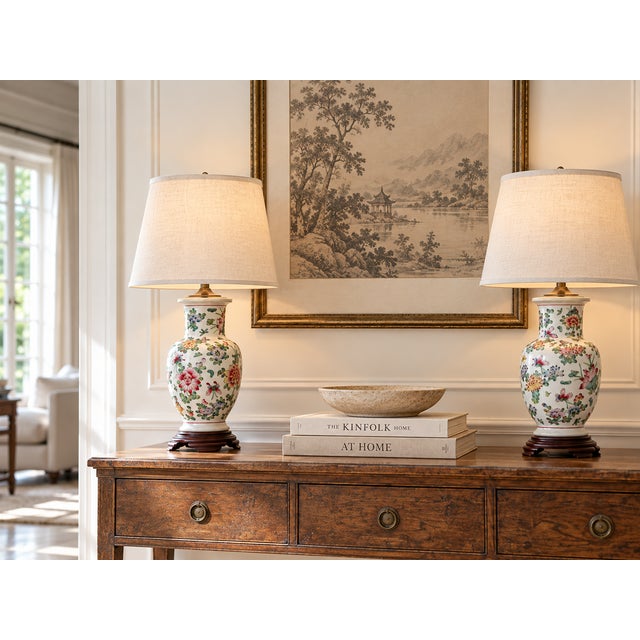 A matched pair of antique Chinese pottery vases, each hand-painted with a lush garden of enamel peonies, butterflies,...