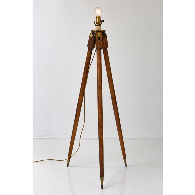 A striking early 20th-century surveyor’s tripod, thoughtfully converted into a sculptural floor lamp. This piece retains...