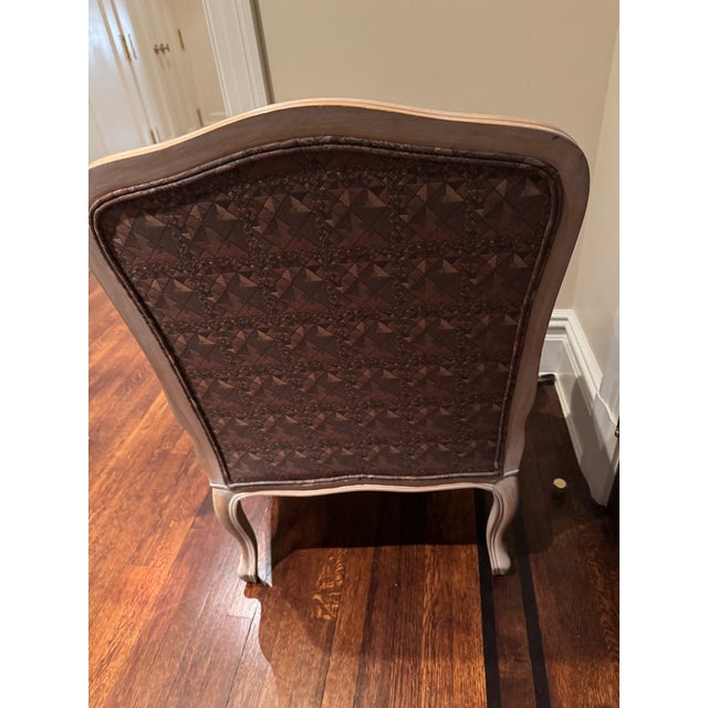 A beautifully proportioned Louis XV–style bergère lounge chair, distinguished by its softly distressed painted frame and...