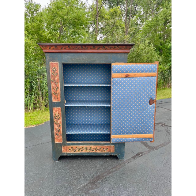 A wonderful example of Alpine folk-painted furniture, this single-door pine armoire retains its original surface and hand-...