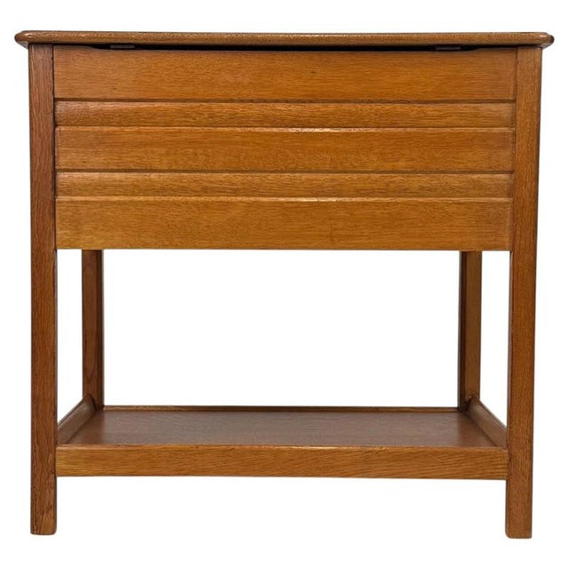 A charming early 20th-century English storage box on stand, finely crafted from oak and distinguished by its compact...