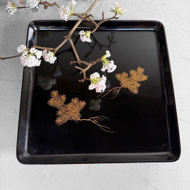 This square Japanese tray is made of deep black lacquered wood and stands on four elegant feet. Dimensions: height 4.5 cm,...