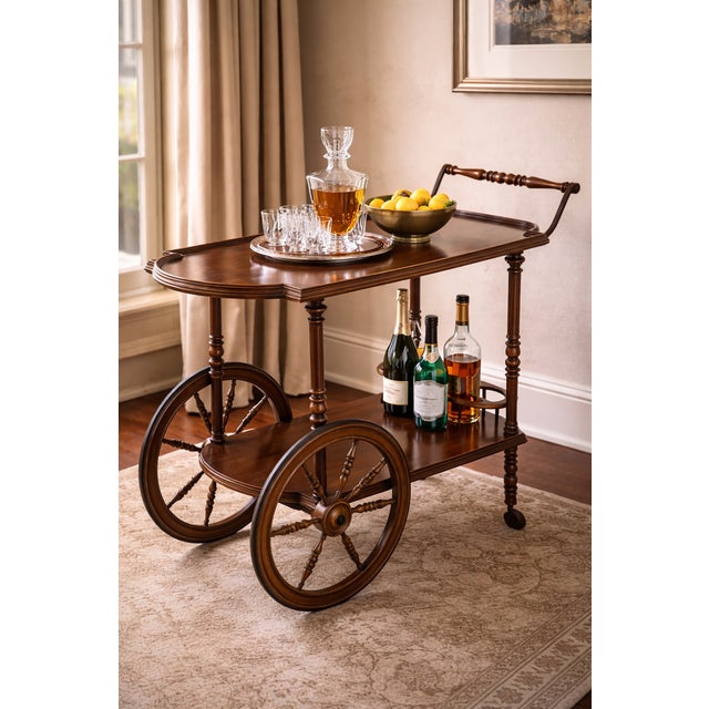 This elegant mid-20th century English mahogany bar cart features classic turned legs, sculptural wooden wheels, and a...