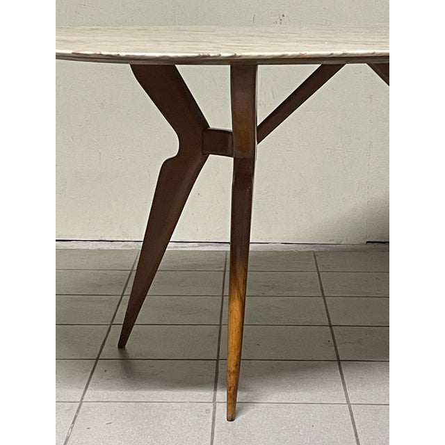 Italian-made oval table from the 1950s with stained beech legs and a marble top. The marble top's dimensions provide space...