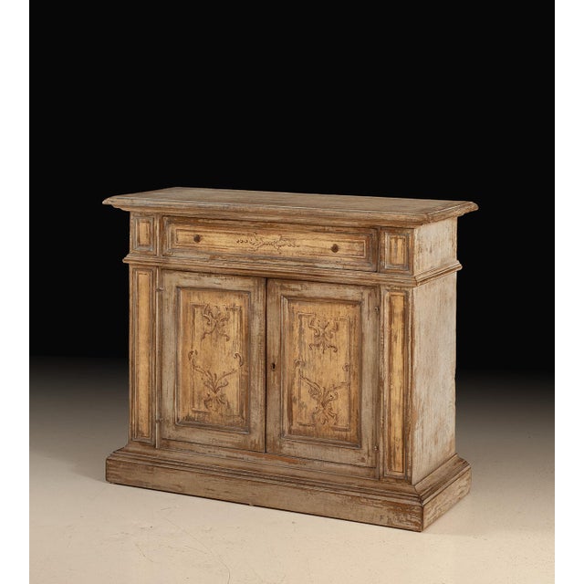 Handcrafted in Italy, this rustic sideboard features a hand-painted distressed finish with warm, weathered tones that give...