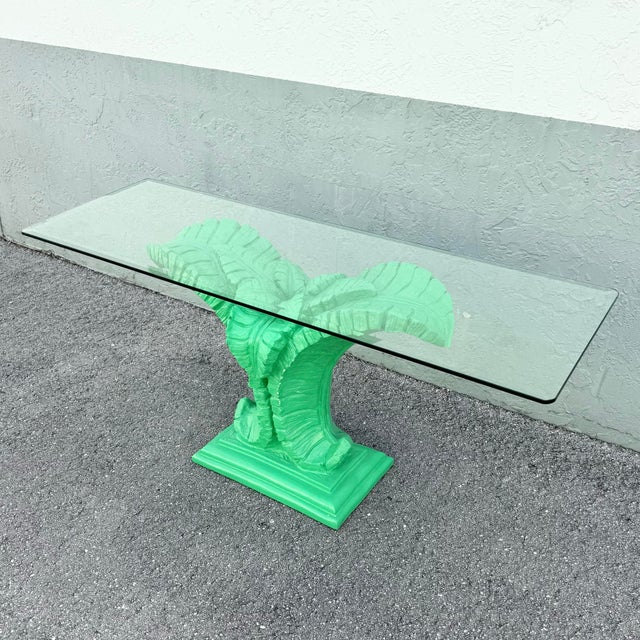 Striking boho chic console table featuring a sculptural banana leaf base in a bold green finish. The intricately textured...