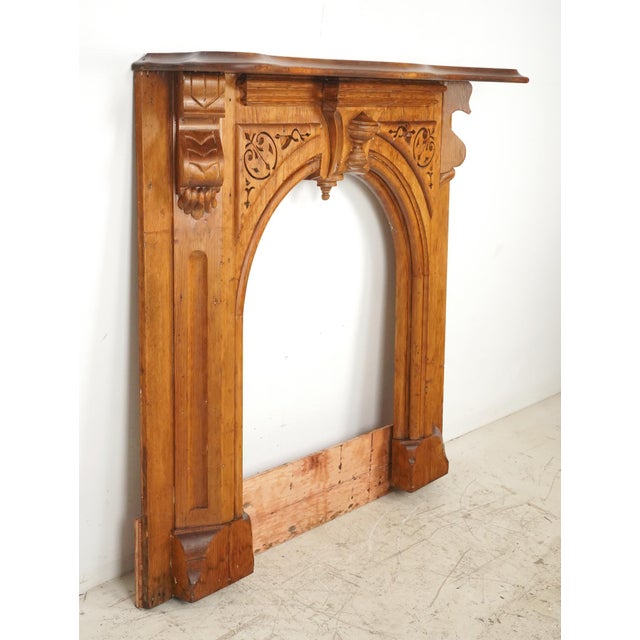 Late Victorian wood arched mantel in medium tones. A blend of scrollwork and geometric carvings mix traditional Victorian...
