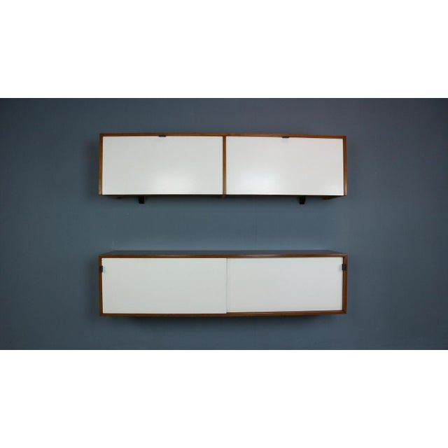 Two walnut and formica wall mount storage cabinets or credenzas designed by Florence Knoll for Knoll Associates. Early...
