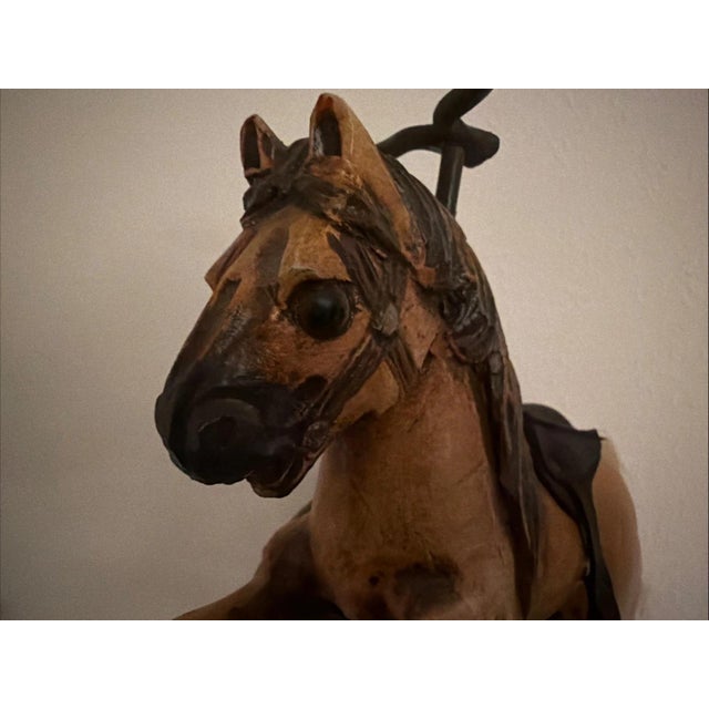 The Antique Toy Hand Carved Horse Tricycle features intricate metal details and a leather saddle, adding to its authentic...