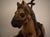 The Antique Toy Hand Carved Horse Tricycle features intricate metal details and a leather saddle, adding to its authentic...