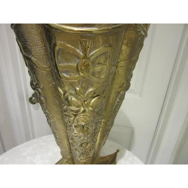 Mid century modern brass umbrella stand. This piece is heavily embossed with flowers and swans. It's in the shape of an...
