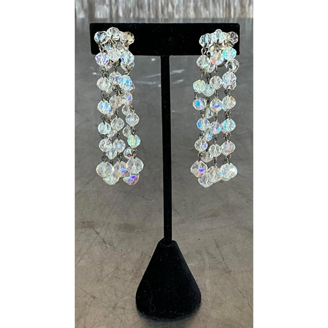 These vintage clip-on earrings fall in a long, linear cascade of faceted crystal beads, each earring built from three...