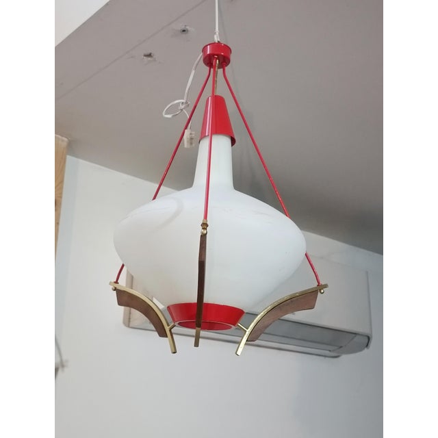 Beautiful Scandinavian pendant lamp. 1960s. Red lacquered metal frame. Bentwood and brass details. Large white opaline...