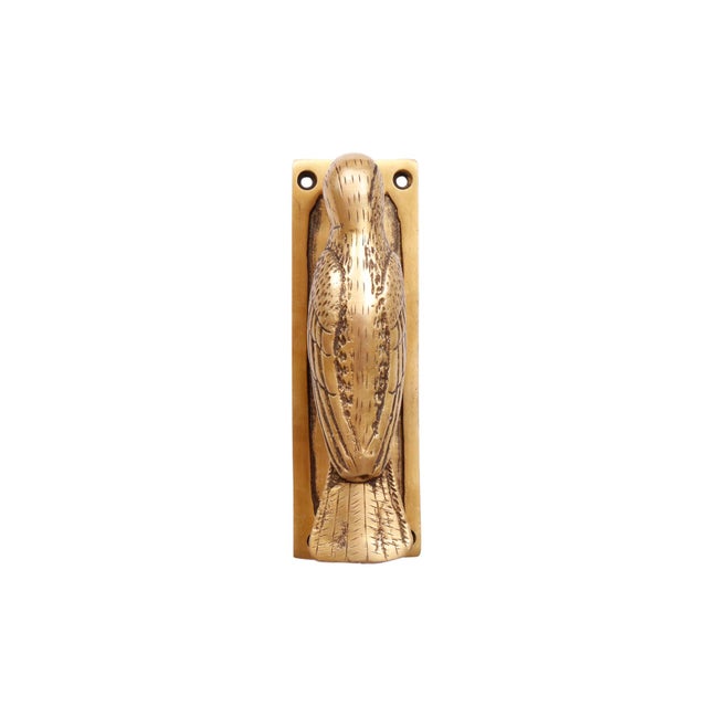 A brass door knocker shaped like a woodpecker. Cast with a prominent beak and tail, finished with line details to define...