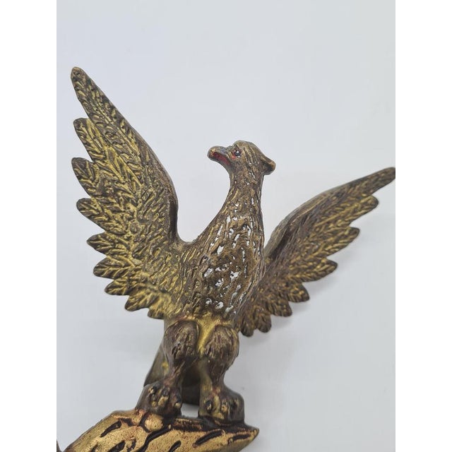 A striking, heavy decorative ashtray featuring a figure of an eagle with outstretched wings, perched on a stylized branch....