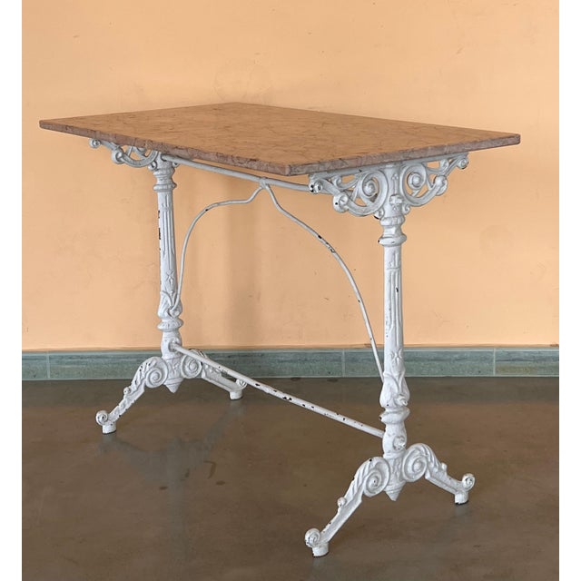 Antique cast iron French pastry style black scrolling "Butterfly" coffee table with marble top. Item features impressive...