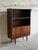 This elegant mid-sized Bookcase features an upper open display shelving unit standing above a lower cabinet compartment....