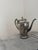 Elegant vintage silver-plated coffee pot featuring a classic tapered silhouette, graceful curved spout, and decorative...