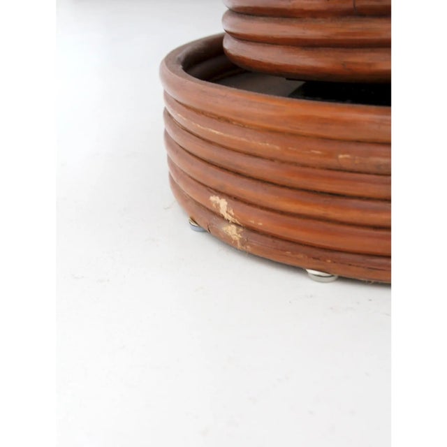 Pair of mid-century rattan swivel lounge chairs with matching ottomans, featuring rounded rattan frames and removable...