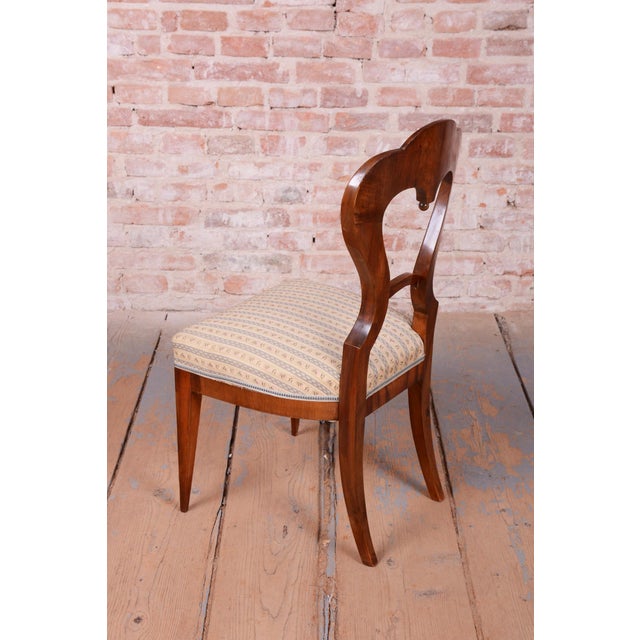 This set of four dining chairs is a magnificent example of refined bourgeois craftsmanship from the Biedermeier period...