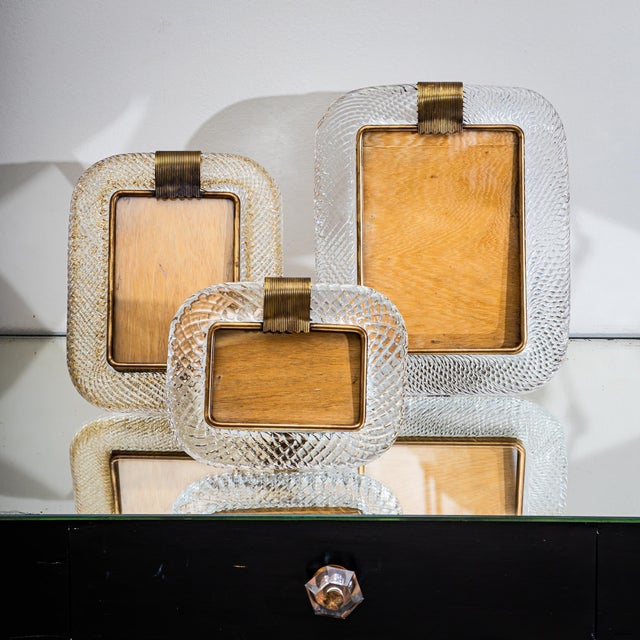 Set of three table frames in twisted Murano glass with brass mounts and inner frames. Each frame is fitted with a rear...