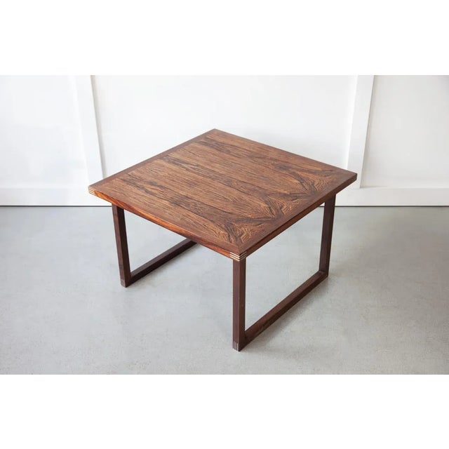 A beautiful Danish coffee table in rosewood with aluminium detailing. Dimensions: Width 69.5cm / Depth 69.5cm / Height 46cm