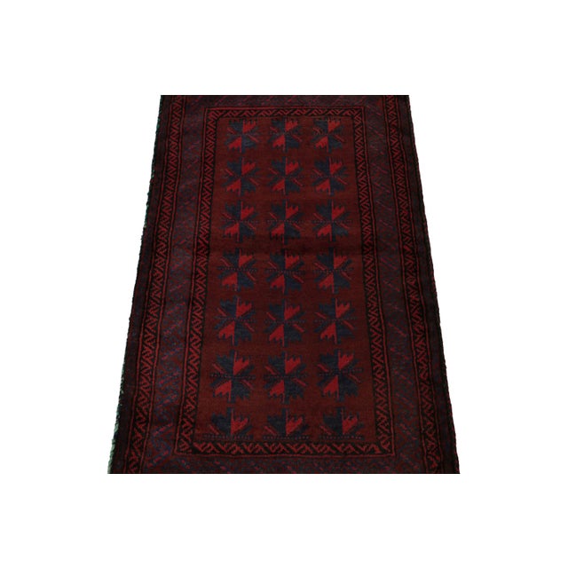 Hand knotted in wool, this 2x4 Baluch scatter rug represents a new line of tribal carpets in the Modern Classics...