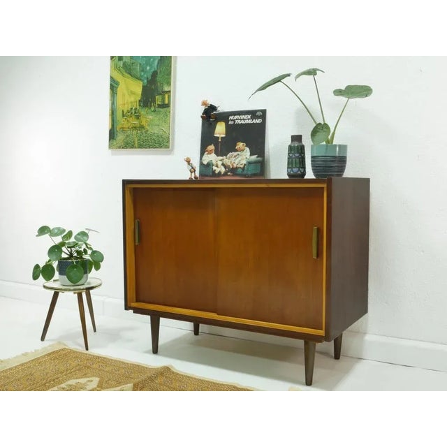 The sideboard is an original from the 1960s. The furniture was originally designed as a combined cabinet for radio and...