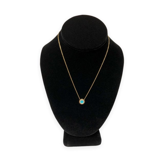 Tiffany & Co. T Collection pendant necklace in 18K yellow gold, featuring turquoise center framed by a halo of round...