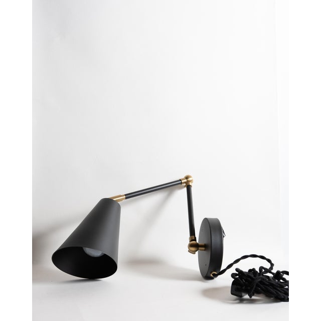 Pair of authentic wall sconces by Cedar & Moss in matte black finish with brass accents. Excellent condition, like new....