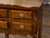 A French walnut side table from the early 20th century, with carved tray top and four small drawers. Created in France...