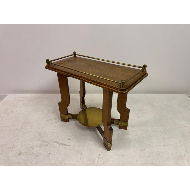 A striking Art Deco oak and brass side table, dating to the 1930s, distinguished by its architectural form and confident...